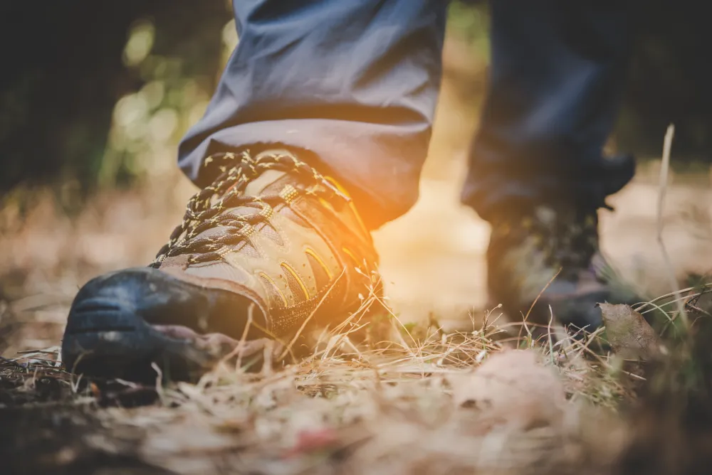 Füße in Wanderschuhen auf einem steinigen Bergpfad
